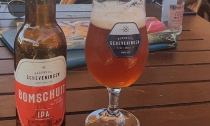 bomschuit ipa  bomschuit ipa van brouwerij scheveningen glas en flesje op tafel op een terras